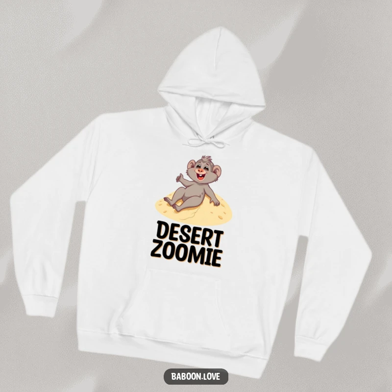 Funny hoodie depicting a giggling baboon enjoying a thrilling slide down a vast sandy dune, radiating pure joy.